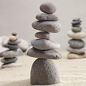 A stack of rocks in the sand on top of each other.