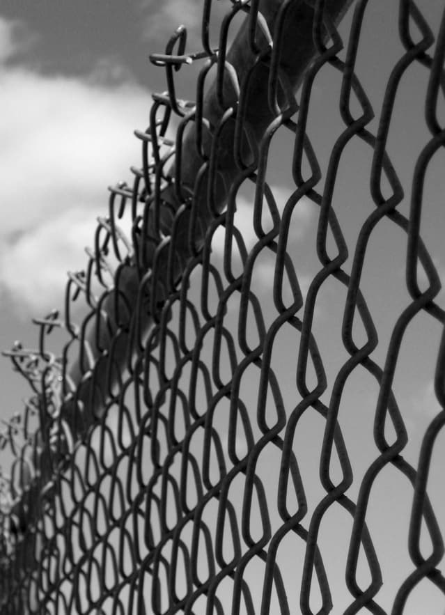 A chain link fence with a sky background