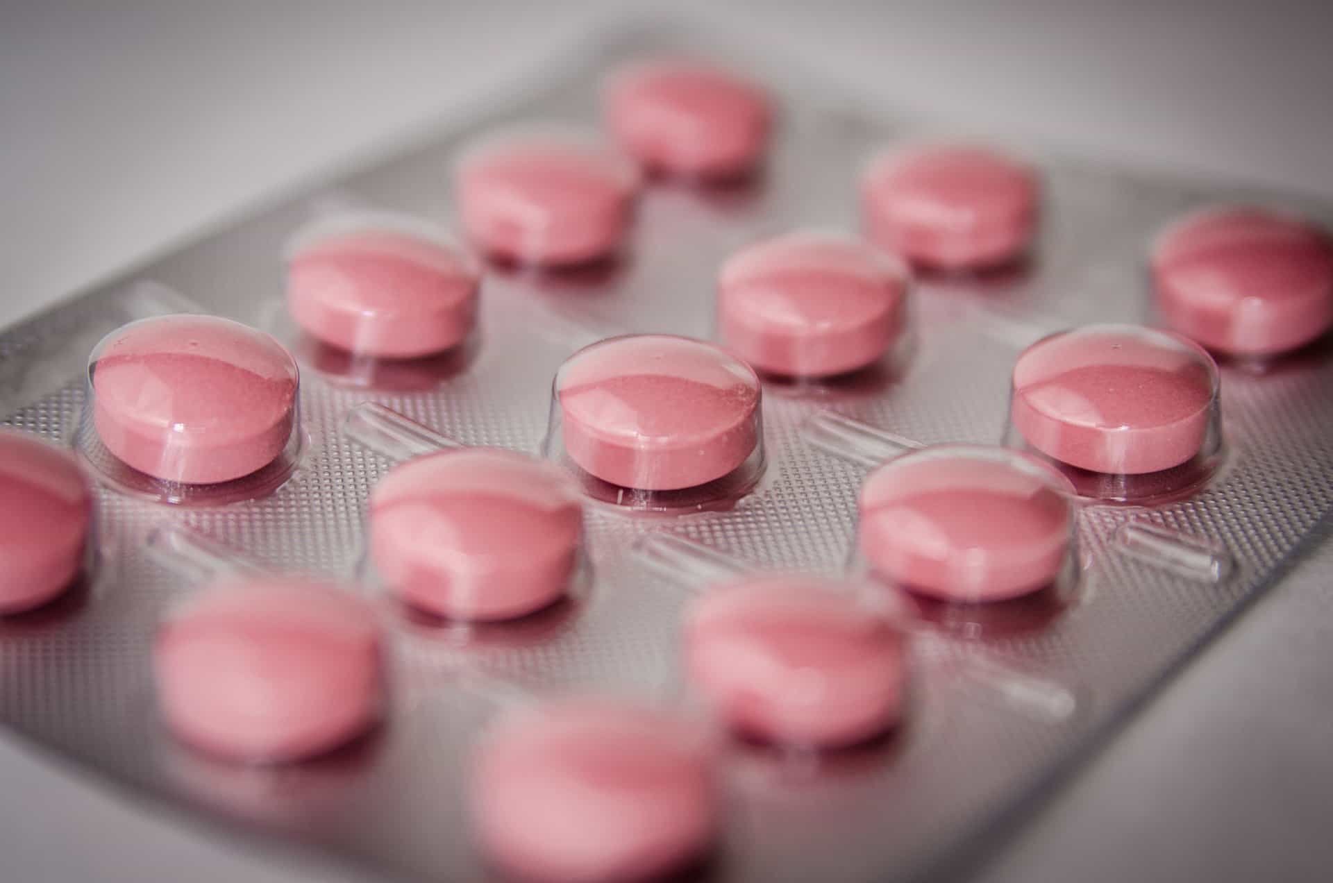 A close up of pink pills in a tray