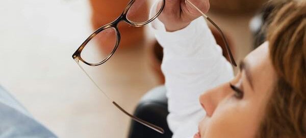 woman laying down with glasses off looking serious
