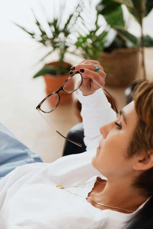 woman laying down with glasses off looking serious