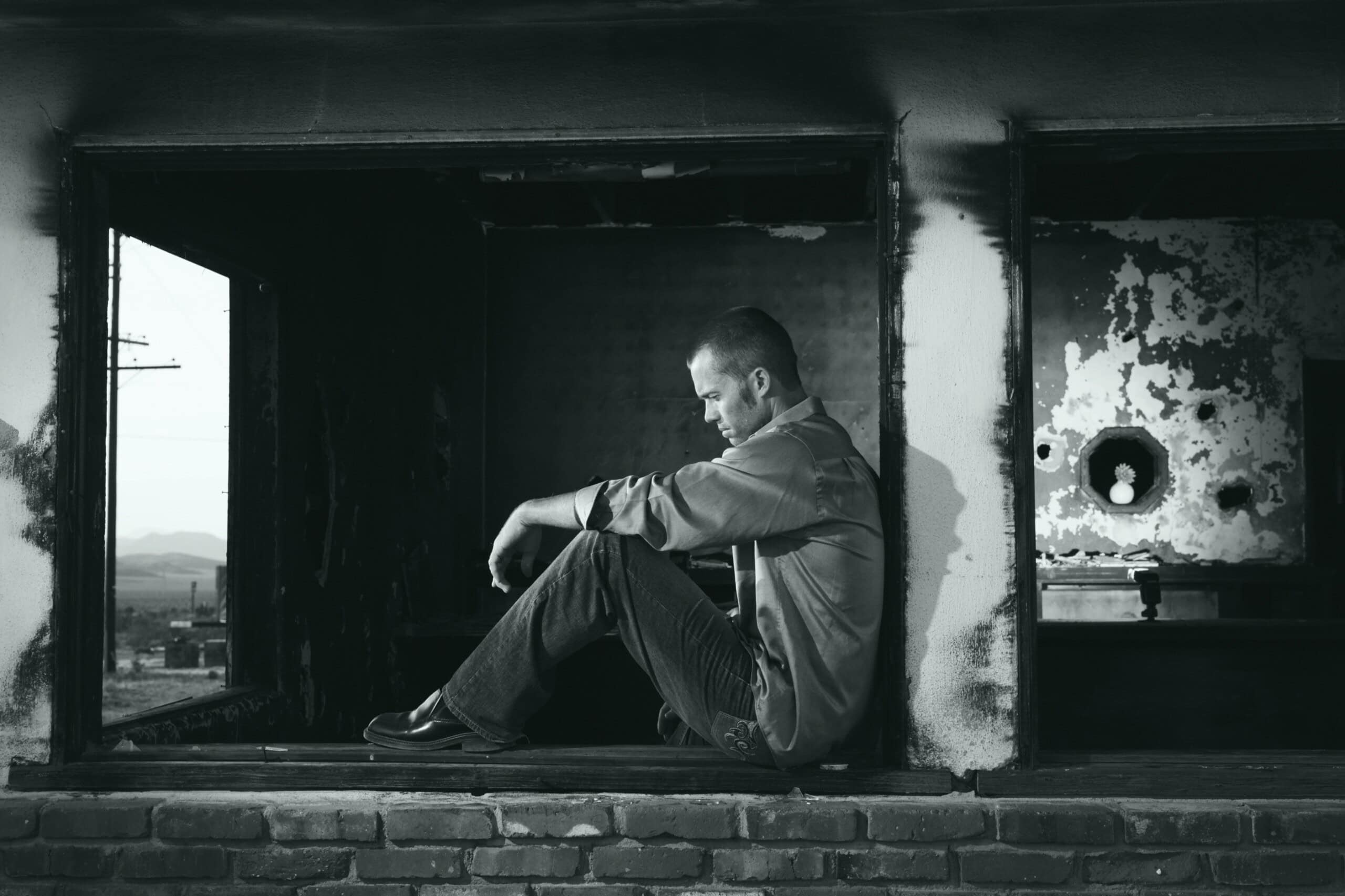 man looking sad under bridge