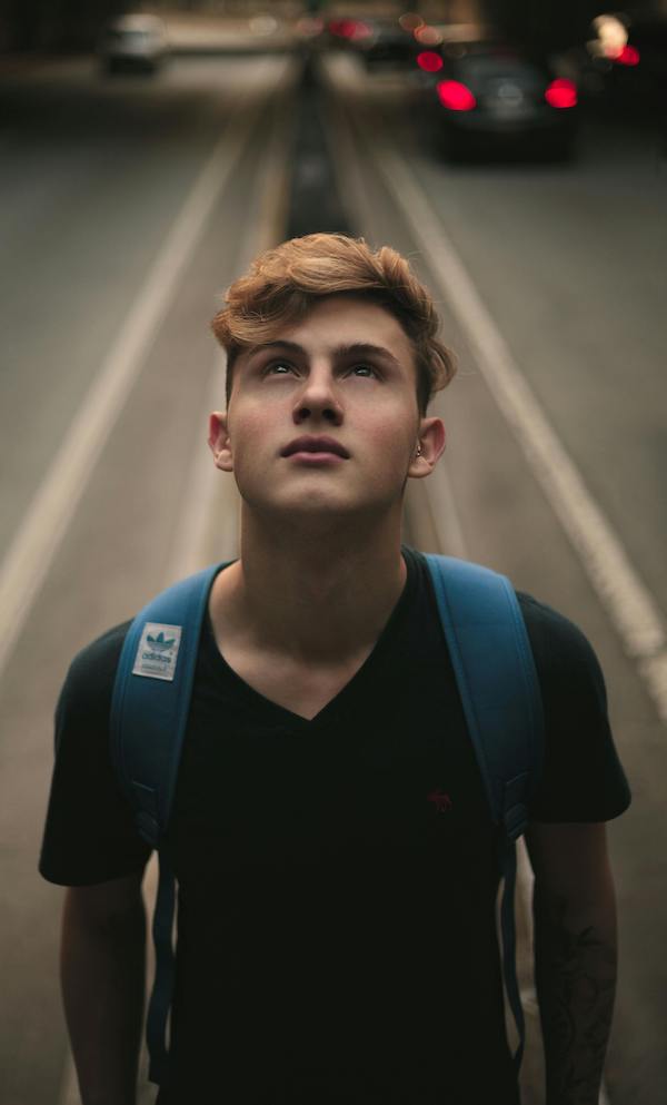 teen boy in middle of the street looking up